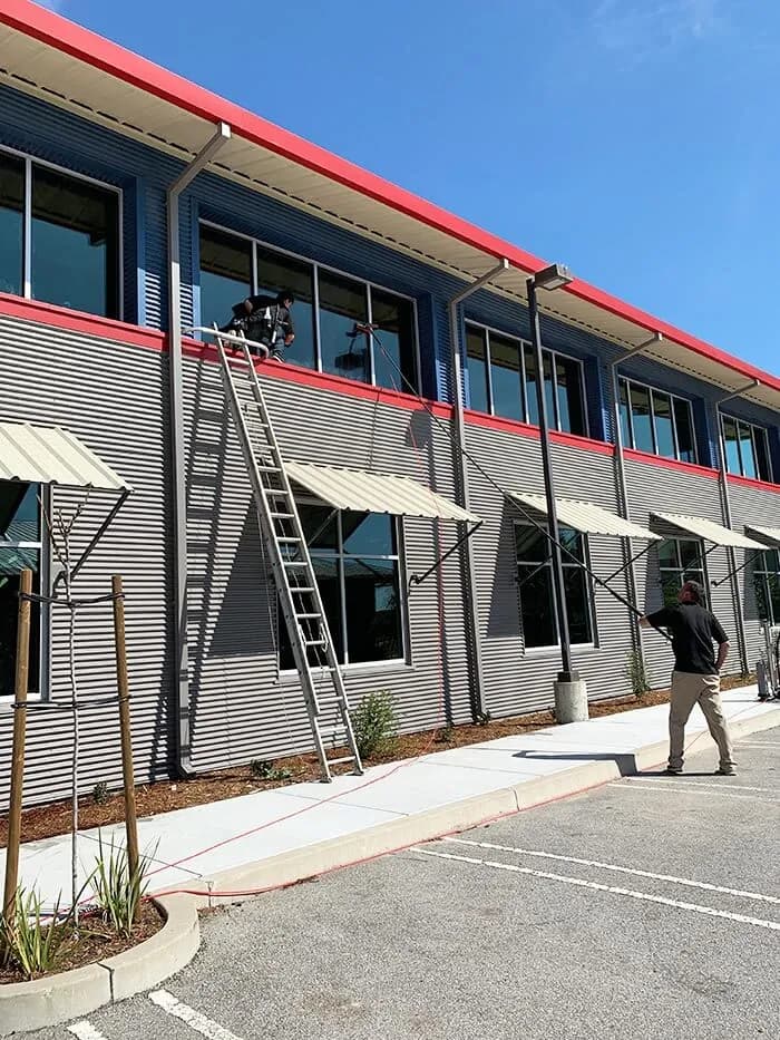 Working on a two story commercial building with red trim and awnings