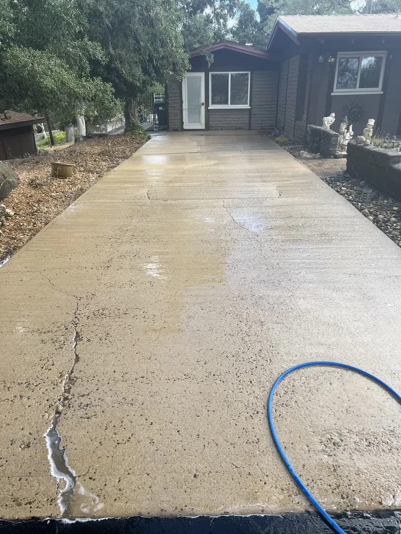 The same residential driveway after pressure washing, showing clean concrete