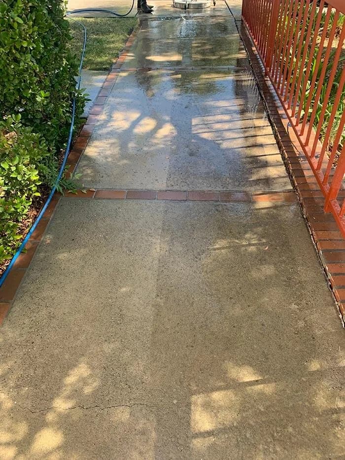 Long residential driveway with one half pressure washed and one half untouched