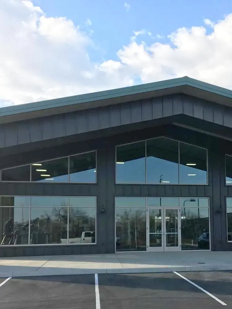 Office building frontage with clean glass doors and windows under a blue sky