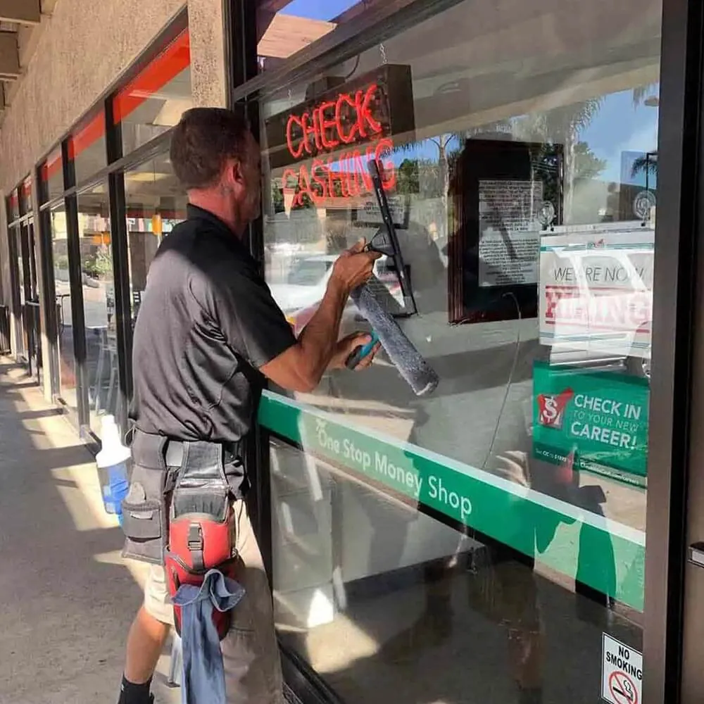 Squeegeeing the exterior glass of a storefront on a Central Coast main street